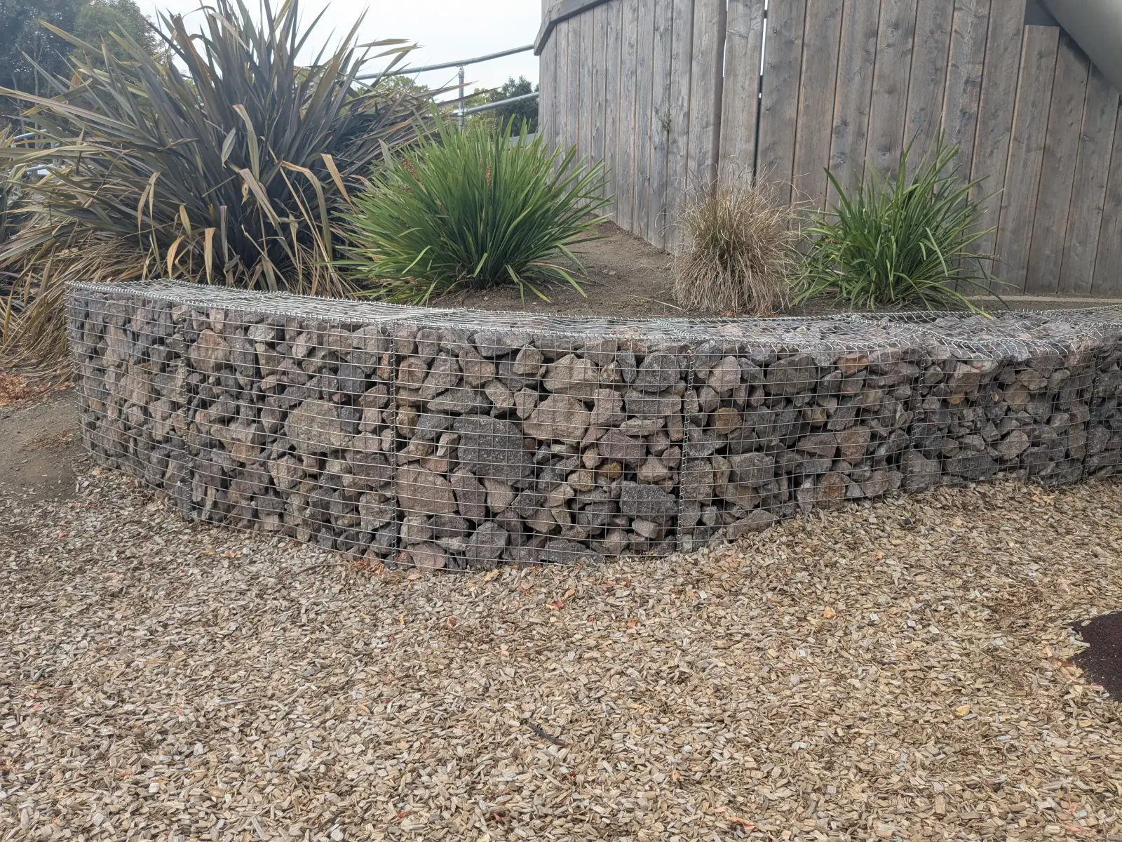 Stone-filled gabion retaining wall